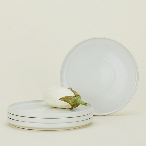 A beautifully arranged set of white dinner plates on a dining table, showcasing elegance and versatility.