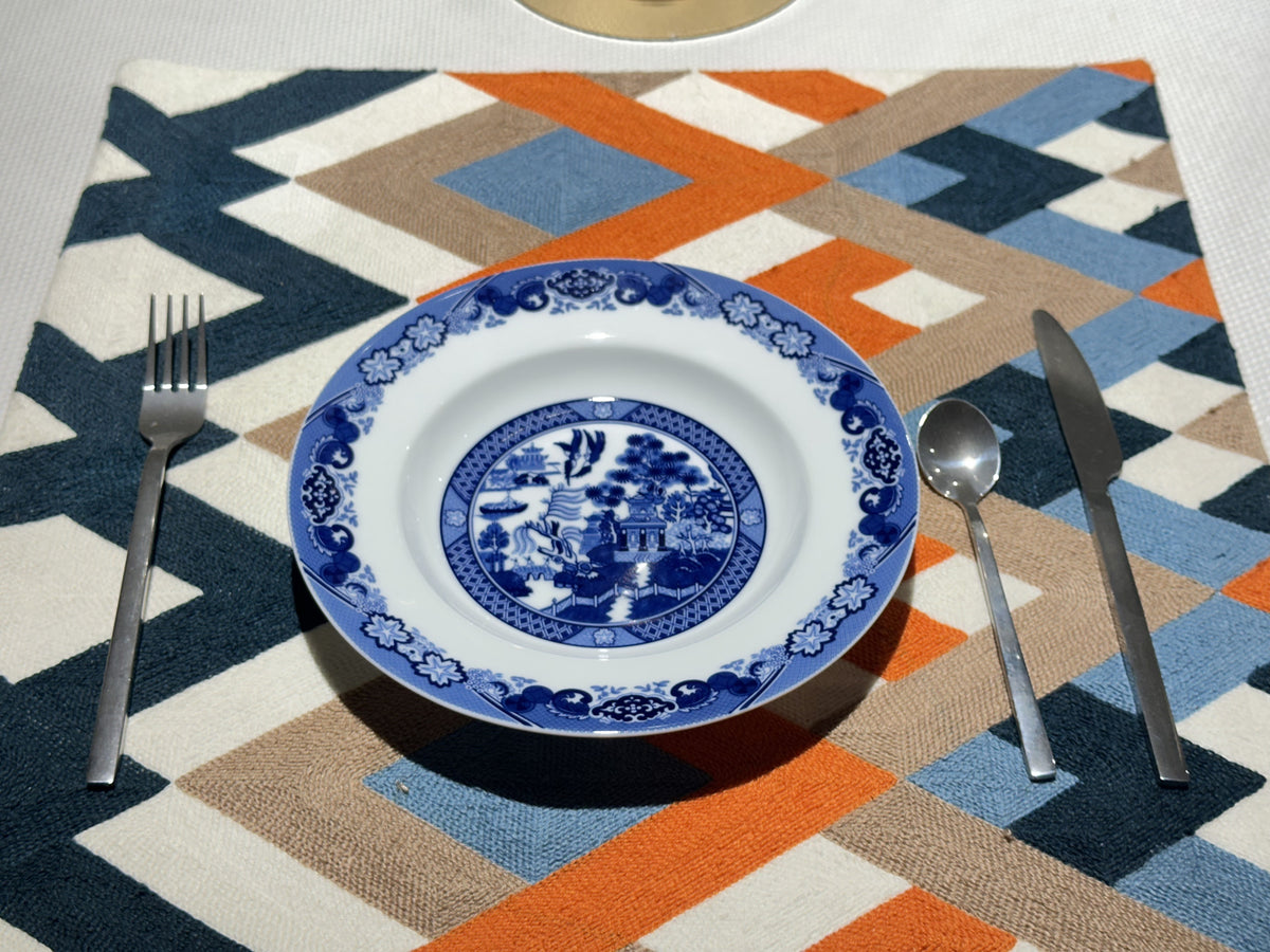 A separate original view of a Classical Gardens plate set with cutlery on a geometric placemat