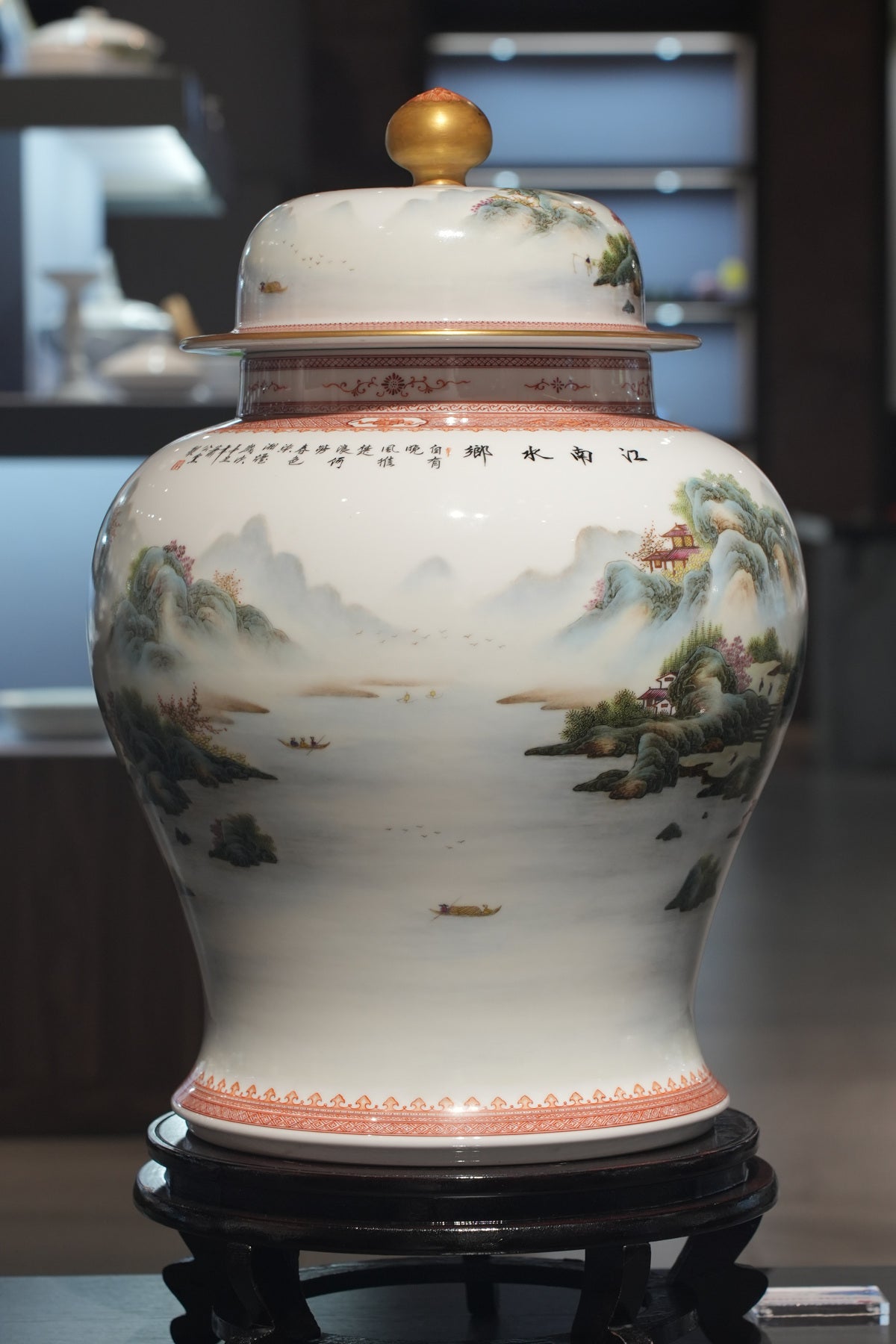 Actual landscape-painted lidded porcelain jar displayed on its wooden stand