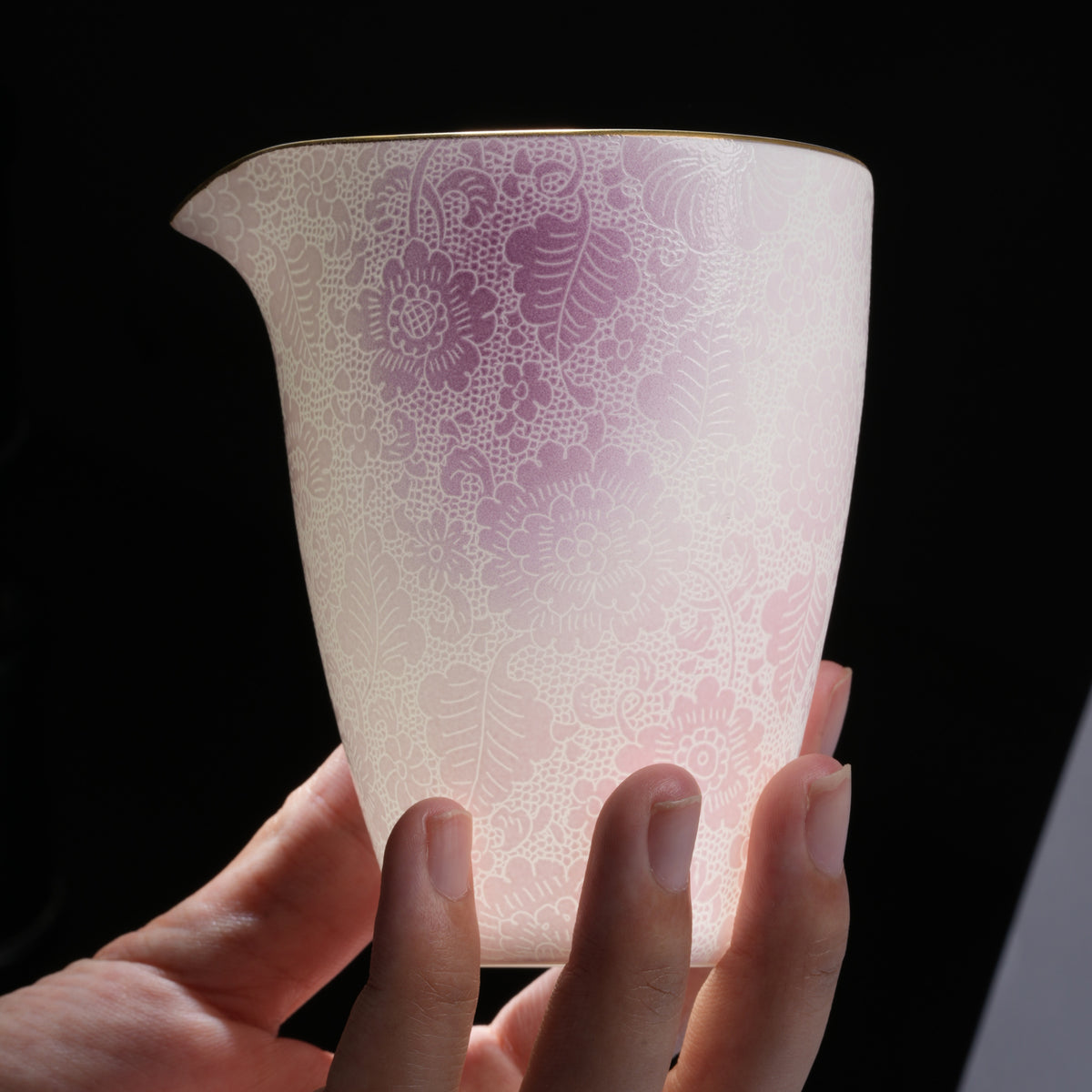 A real photograph of a pink and purple cup held in the hand