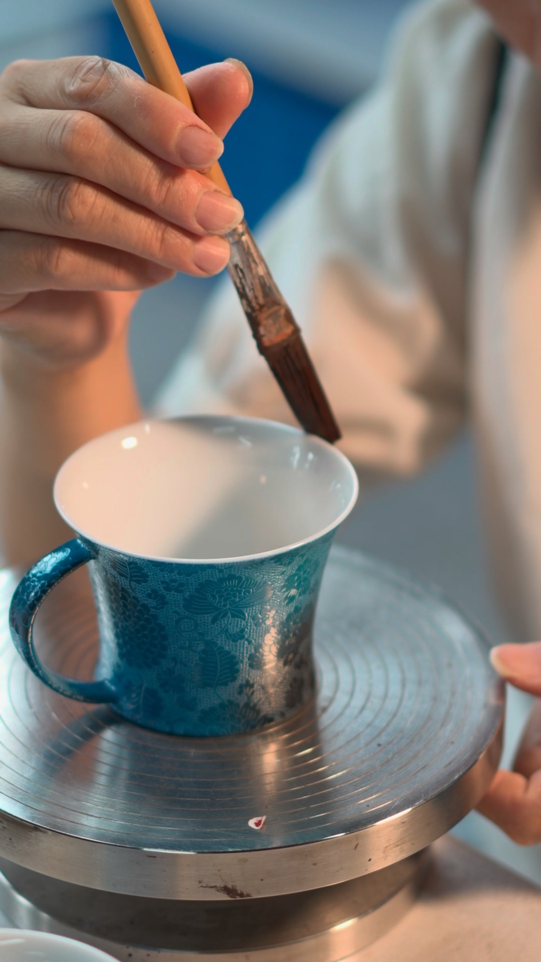 Static frame showing a brush and the decorated surface of a cup